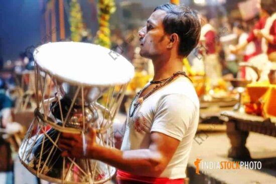 Hindu man playing the damaru at Varanasi Ganga aarti
