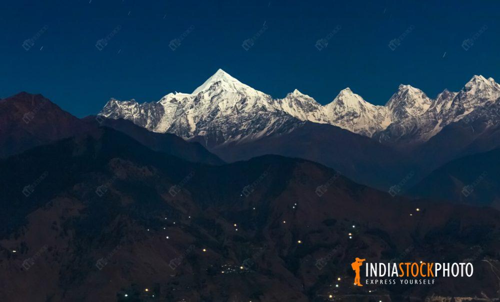 Panchchuli Himalayan snow peaks at night with mountain city lights