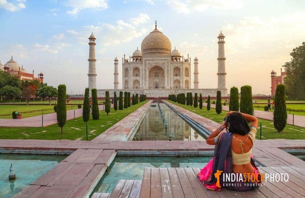 Female tourist taking photographs of the Taj Mahal at sunrise