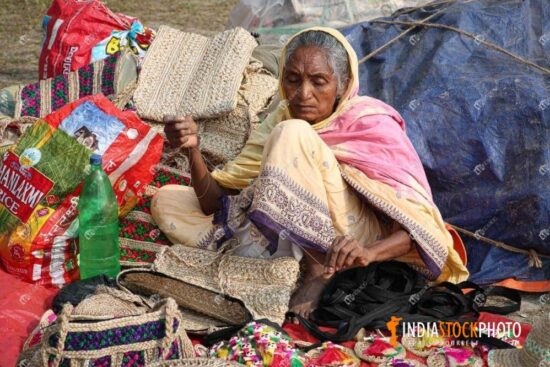 Aged woman making handicraft items for sale at Kolkata fair