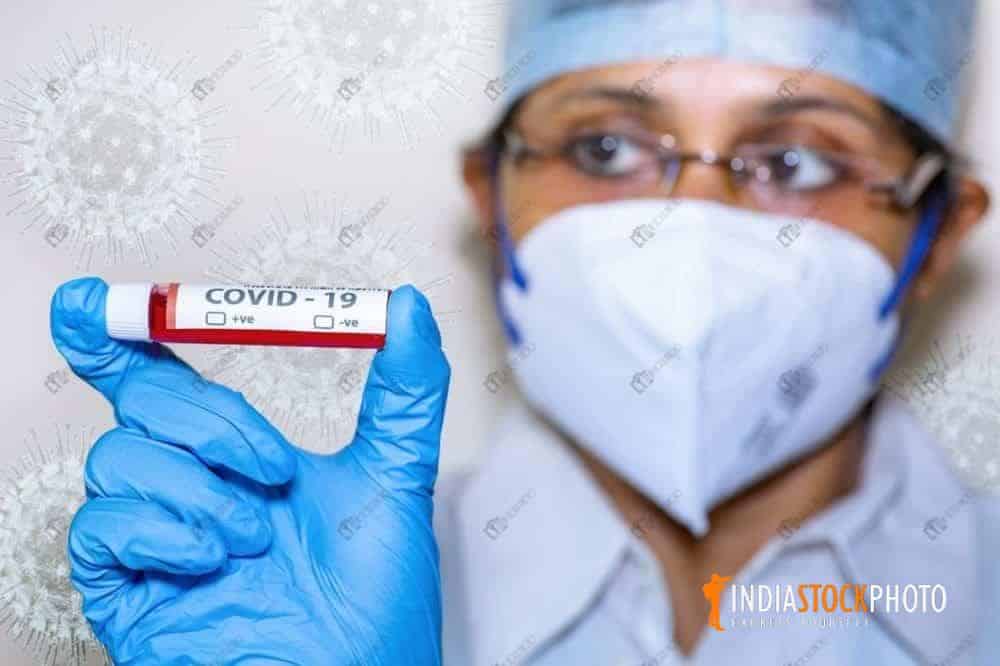 Nurse in face mask hold a blood sample vial of Coronavirus patient