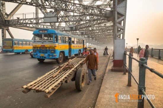 Hand pulled cart with public transport vehicle on Kolkata Howrah bridge
