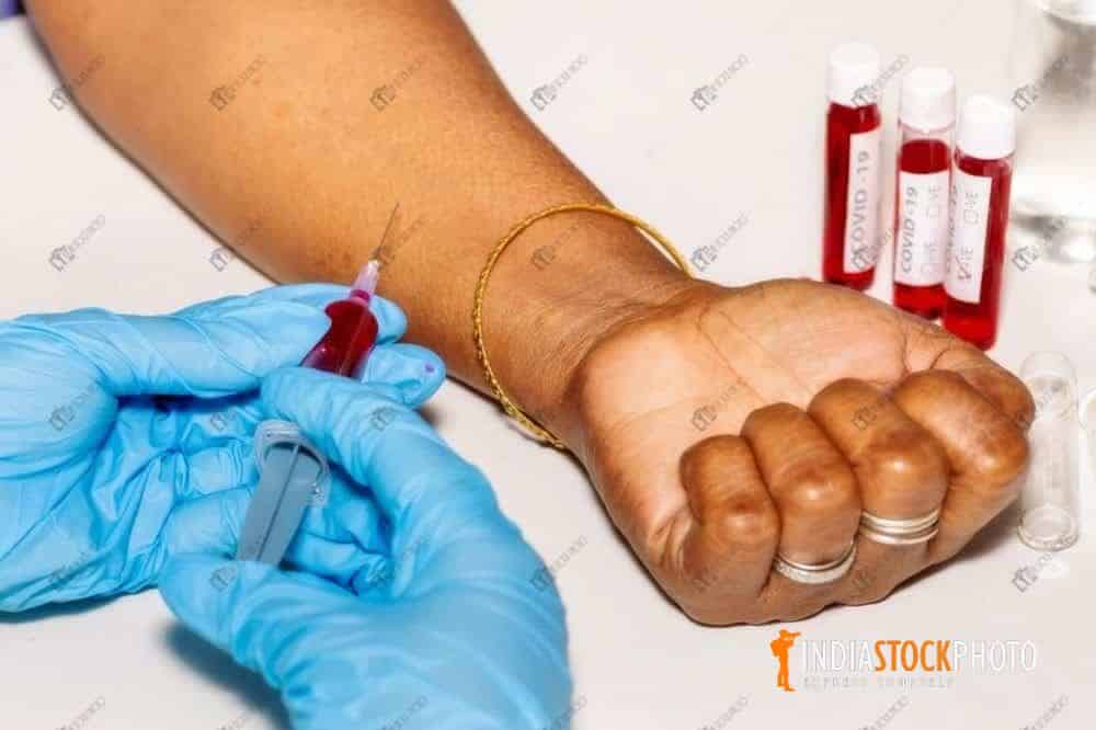 Nurse draws blood sample from woman patient