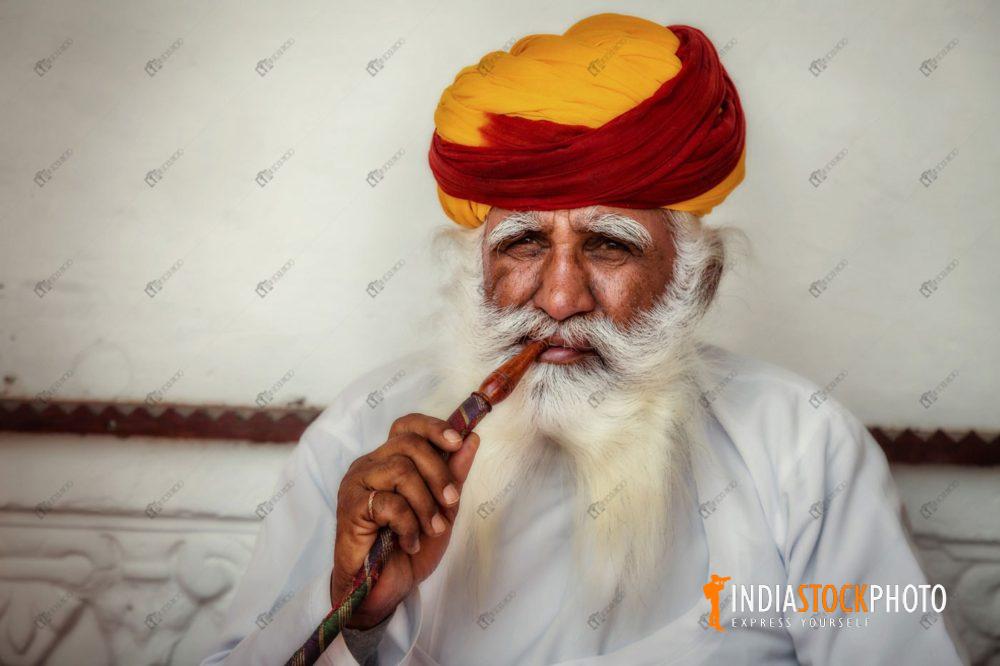 Rajasthani man in traditional outfit smoking a pipe at Mehrangarh Fort