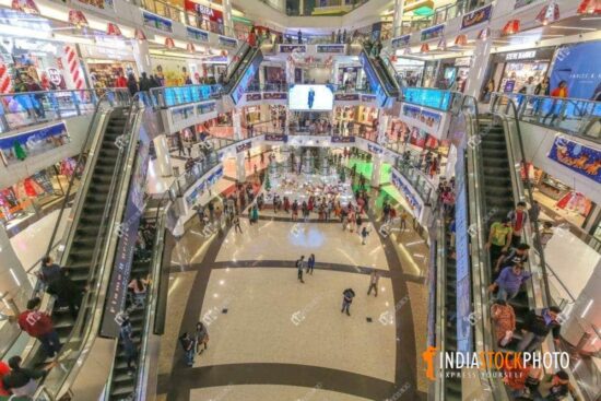 Interior view of city shopping mall with brand stores and escalators