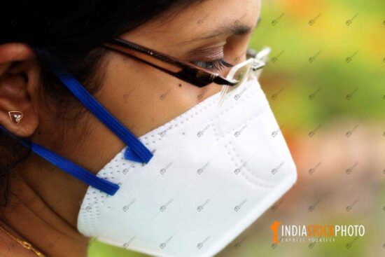 Indian woman wearing a N95 protective face mask in side view