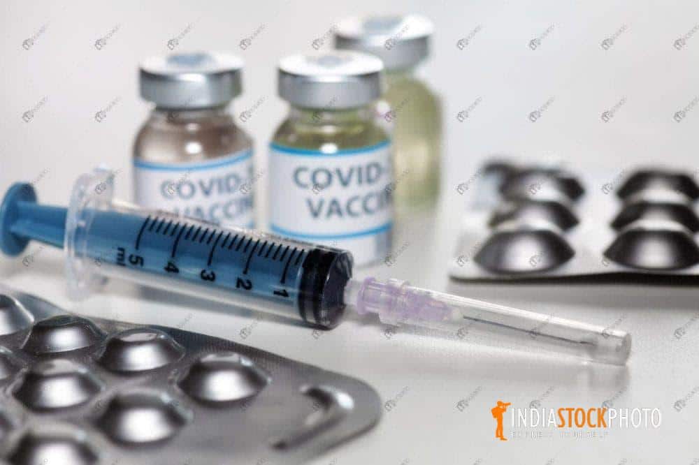 Injection syringe with vaccine bottles and medicinal drugs for Covid treatment