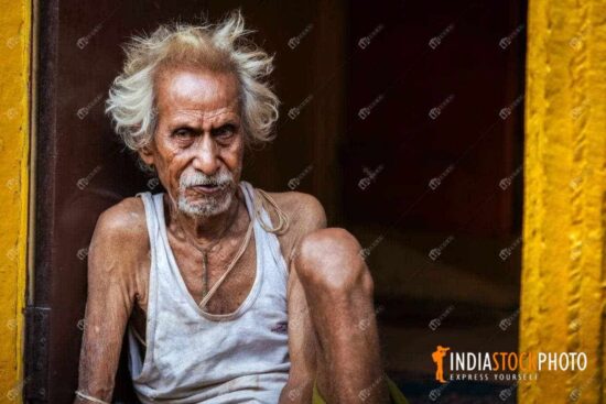 Old man portrait sitting at a Varanasi alleyway