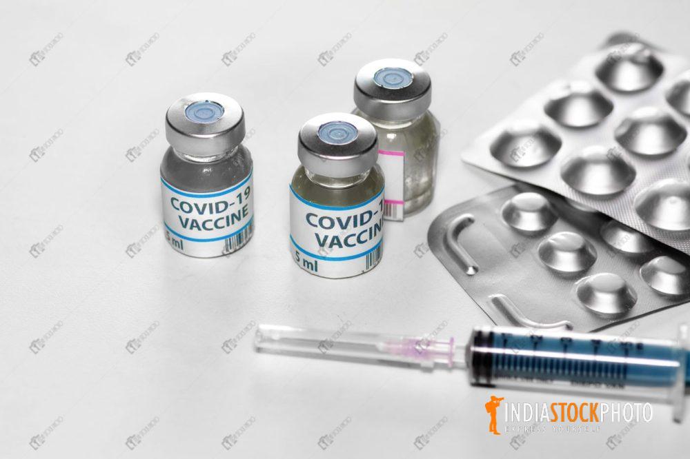 Covid-19 vaccine bottles with injection syringe and medicinal drugs