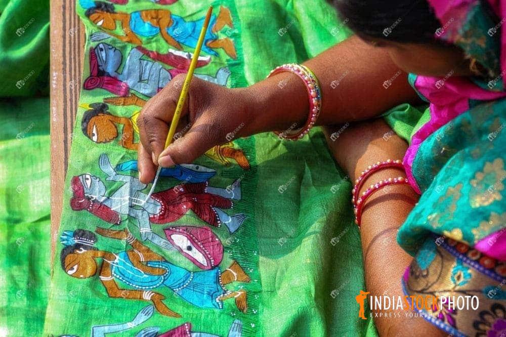 Woman artist painting on ladies dress material at handicraft fair