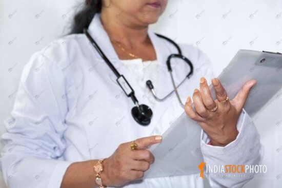 Indian doctor studying medical report clipboard