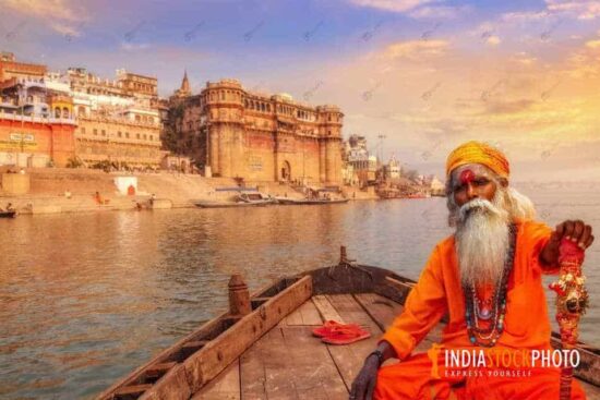 Indian sadhu on a boat on river Ganges at Varanasi at sunset