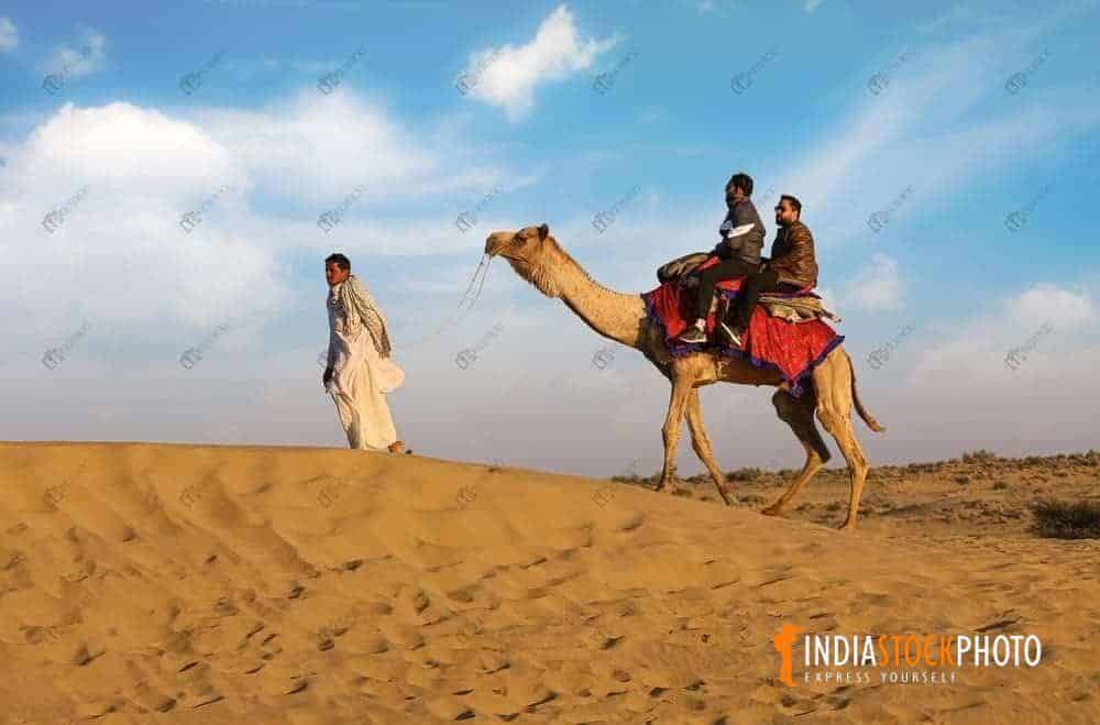 Tourist on camel safari at Jaisalmer Thar desert Rajasthan