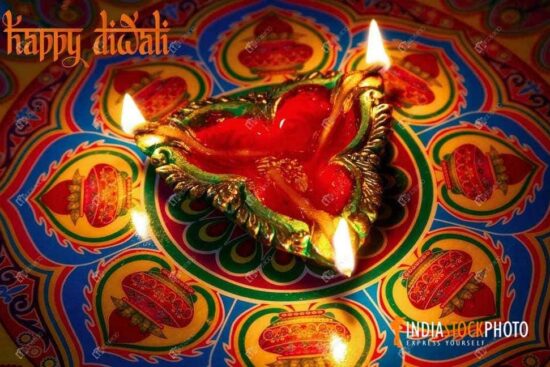 Traditional Diwali festival clay lamp on colorful Rangoli