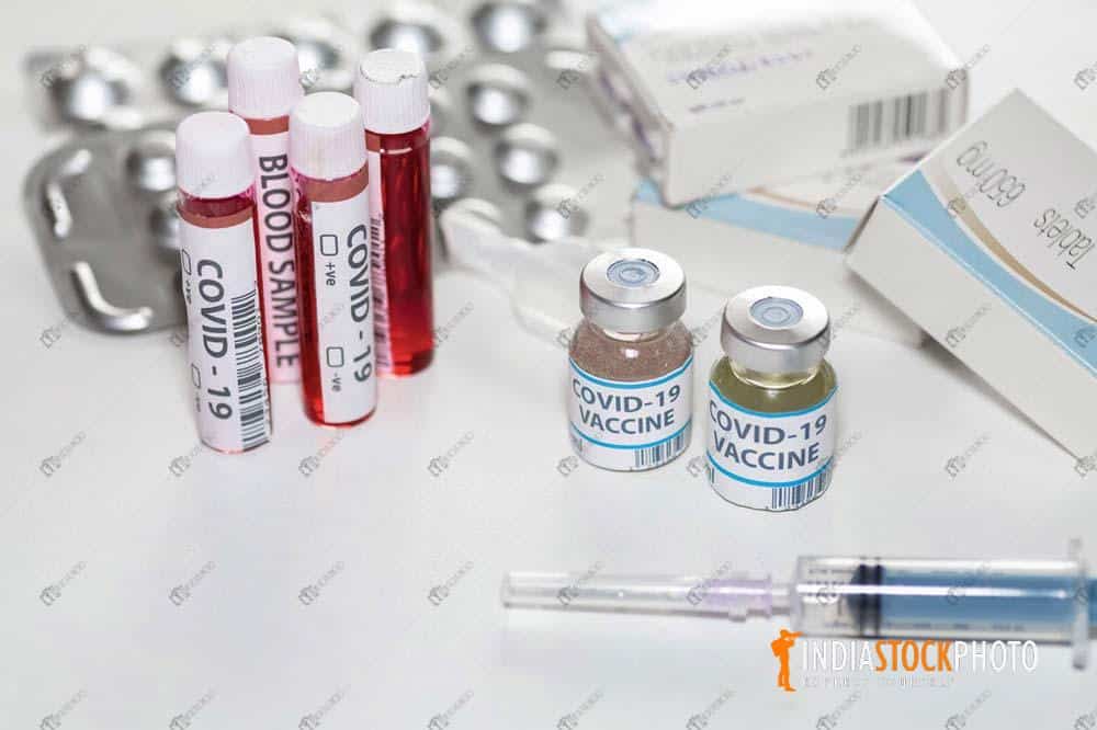 Vaccine bottles with injection syringe and blood vials for medical test