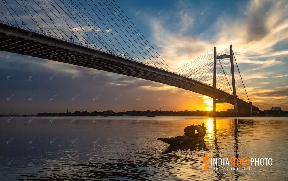Vidyasagar Setu suspension bridge with boat on river Ganges at sunset