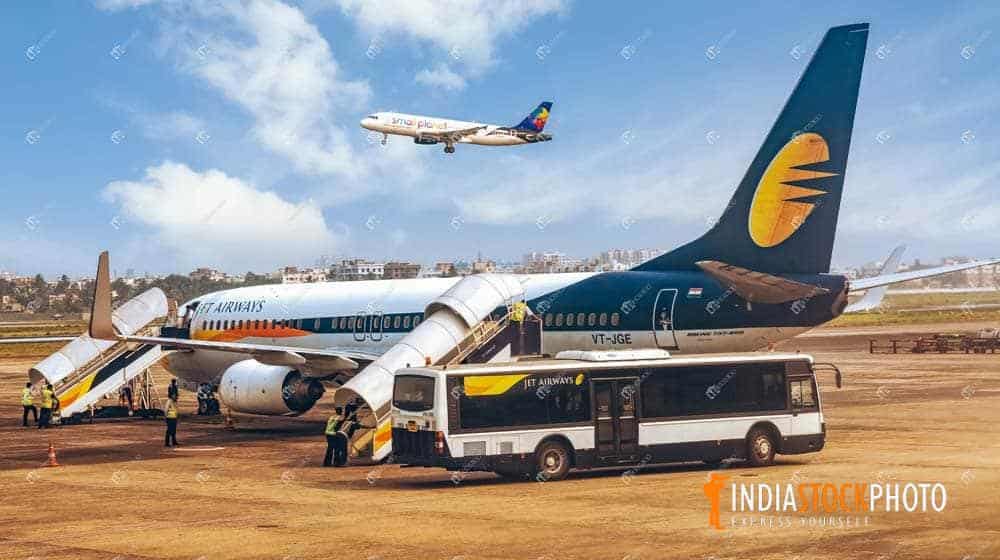 Passenger aircraft on airport tarmac with plane taking off