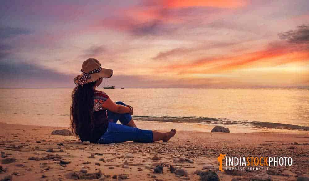 Female tourist enjoy a moody sunset at Havelock islands beach Andaman