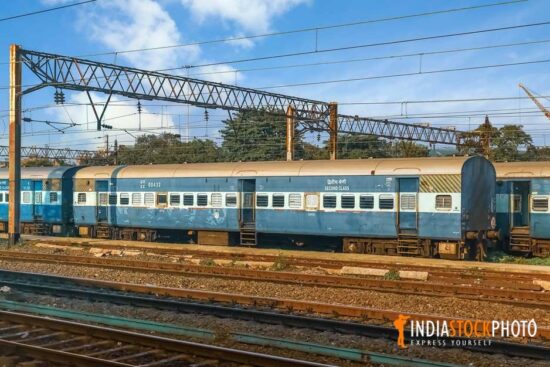 Indian railway coaches standing at a rail yard with view of train tracks