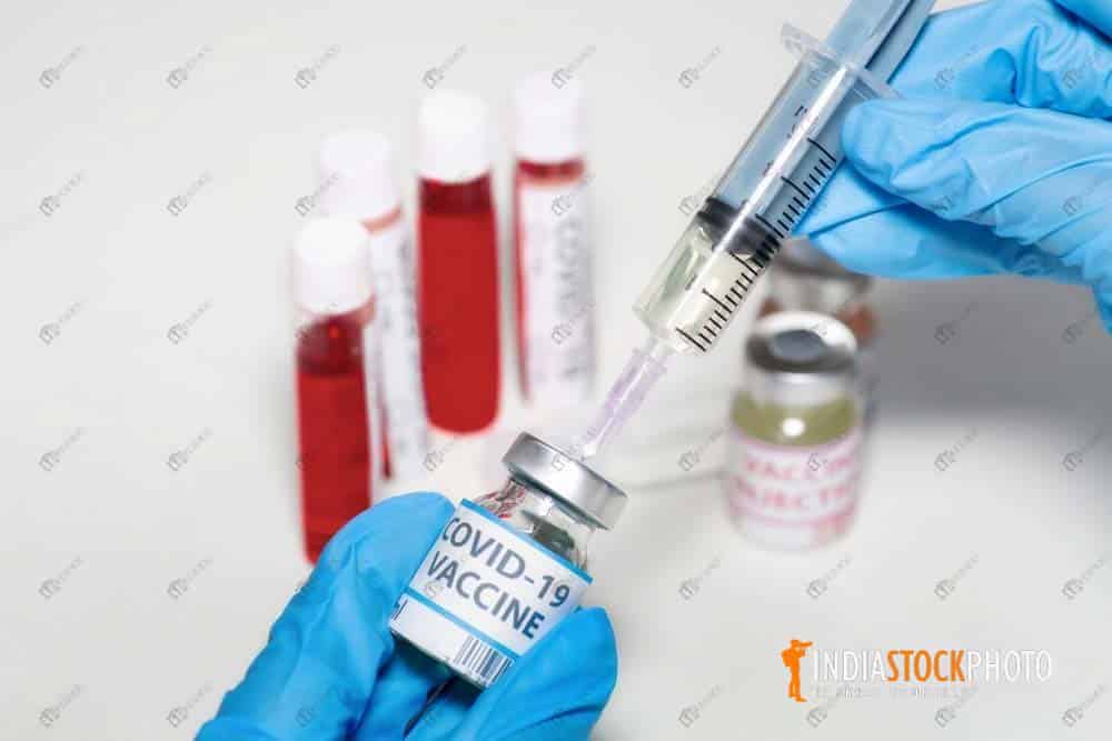 Injection syringe drawing medicine from vaccine bottle