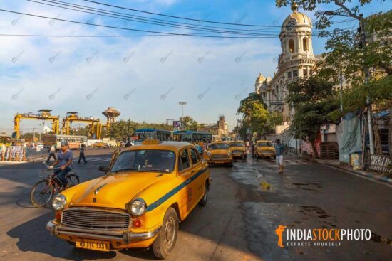 Taxi at city road crossing with old heritage buildings at Kolkata