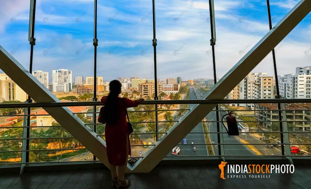 Woman standing at an office balcony with view of Kolkata cityscape