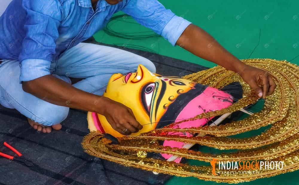 Artist working on a mask of Goddess Durga used in regional folk dance