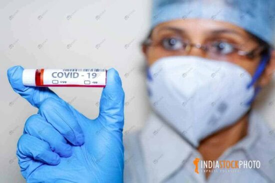 Nurse holds a coronavirus blood sample vial in her hand