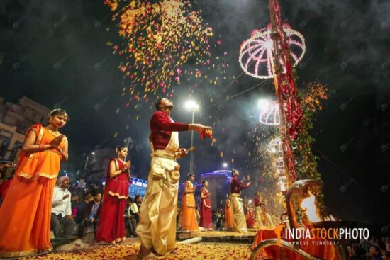 Hindu priests shower flower petals at Ganga aarti ritual ceremony at Varanasi