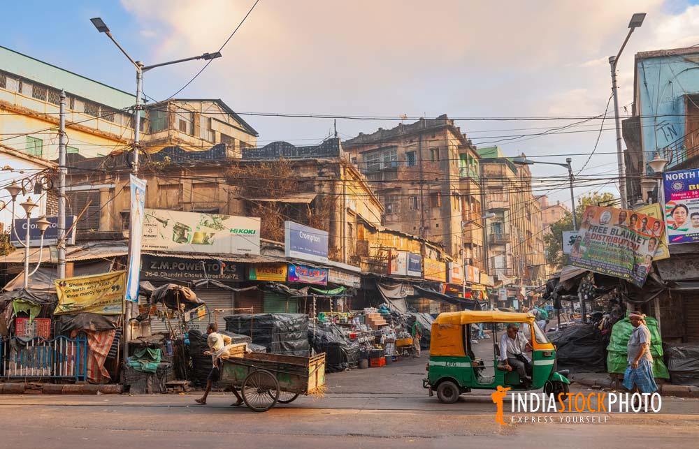 Old city market with roadside shops and vehicles at Kolkata