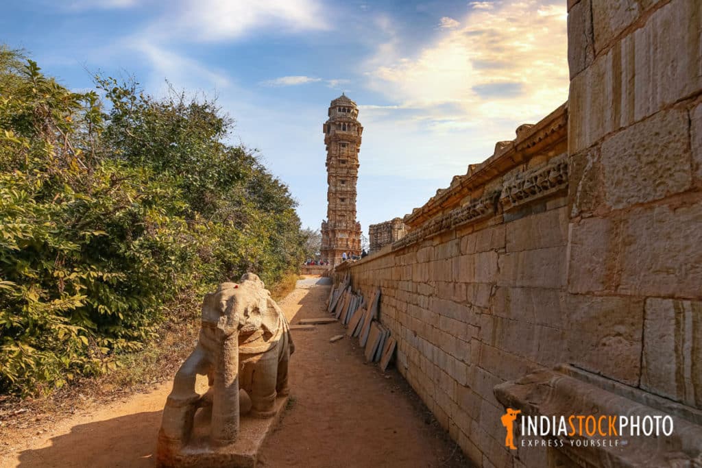 Ancient stone elephant with view of the victory monument or Vijaya Stambha at Chittorgarh Fort