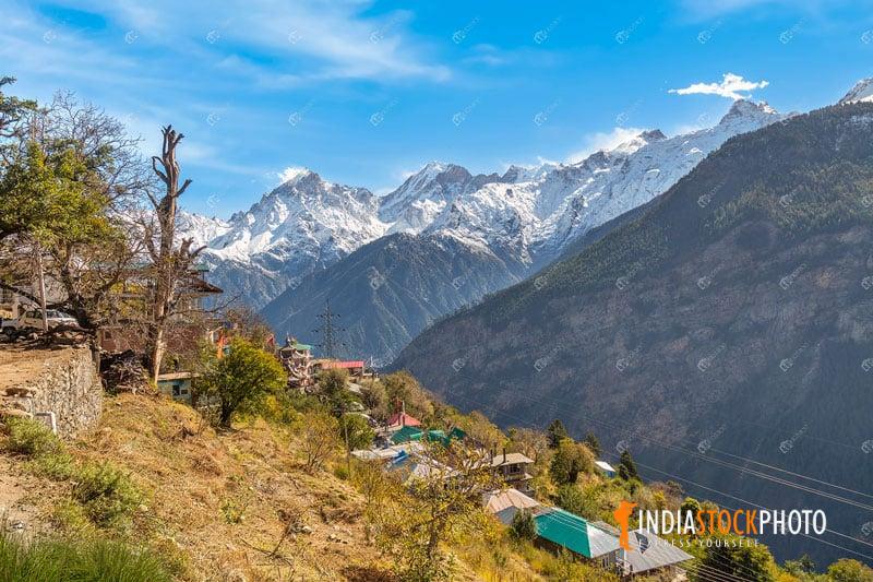Rural village on mountain slopes with Kailas Himalaya range