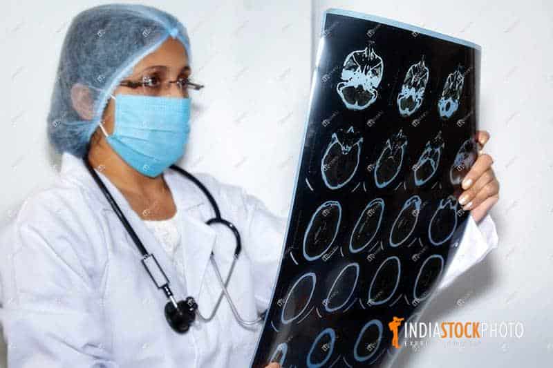 Indian female radiologist examine a CT brain scan plate