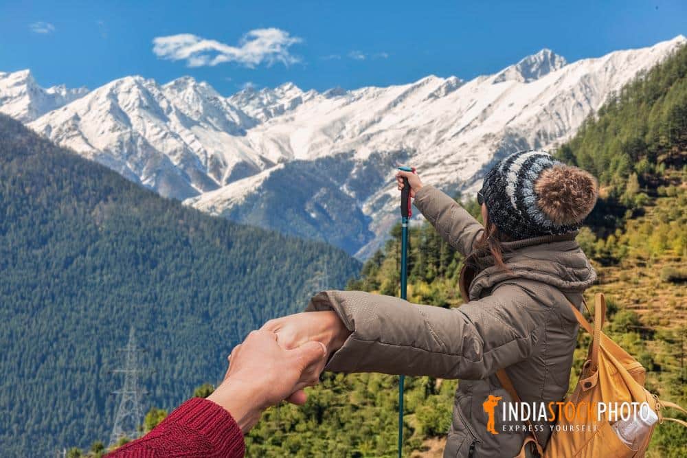 Female tourist hiker enjoy view of the Kailash Himalaya mountain range at Kalpa