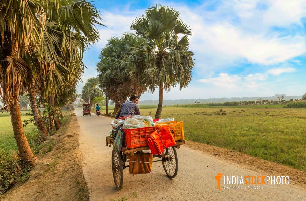 Man on his cycle cart selling essential commodities on a village road