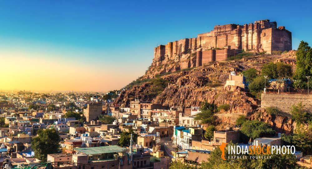 Mehrangarh Fort on top of a cliff with Jodhpur cityscape at sunset