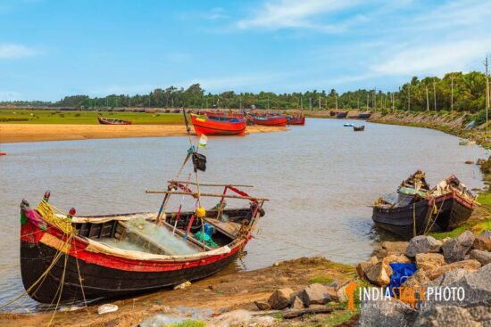 Fishing boats lined up at the Rupnarayan river bank with scenic rural landscape