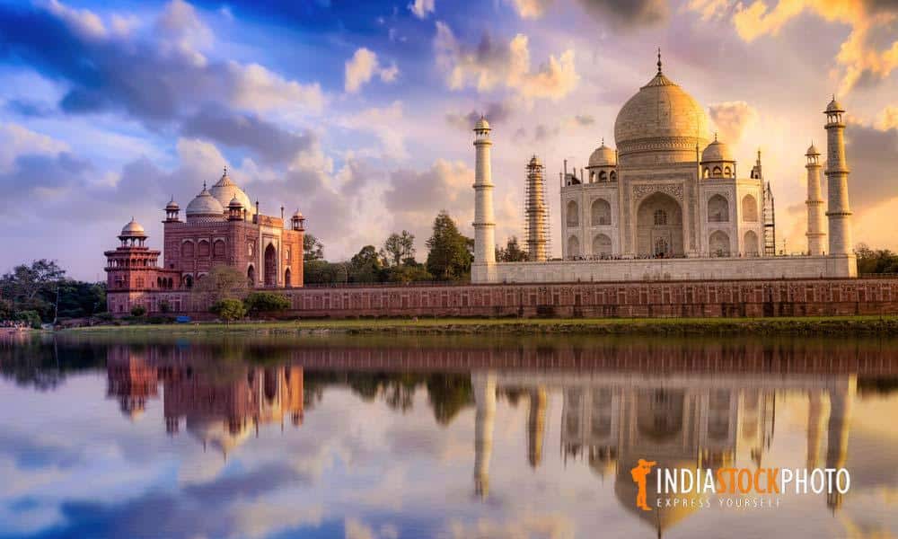 Taj Mahal on the banks of river Yamuna with moody sunset sky